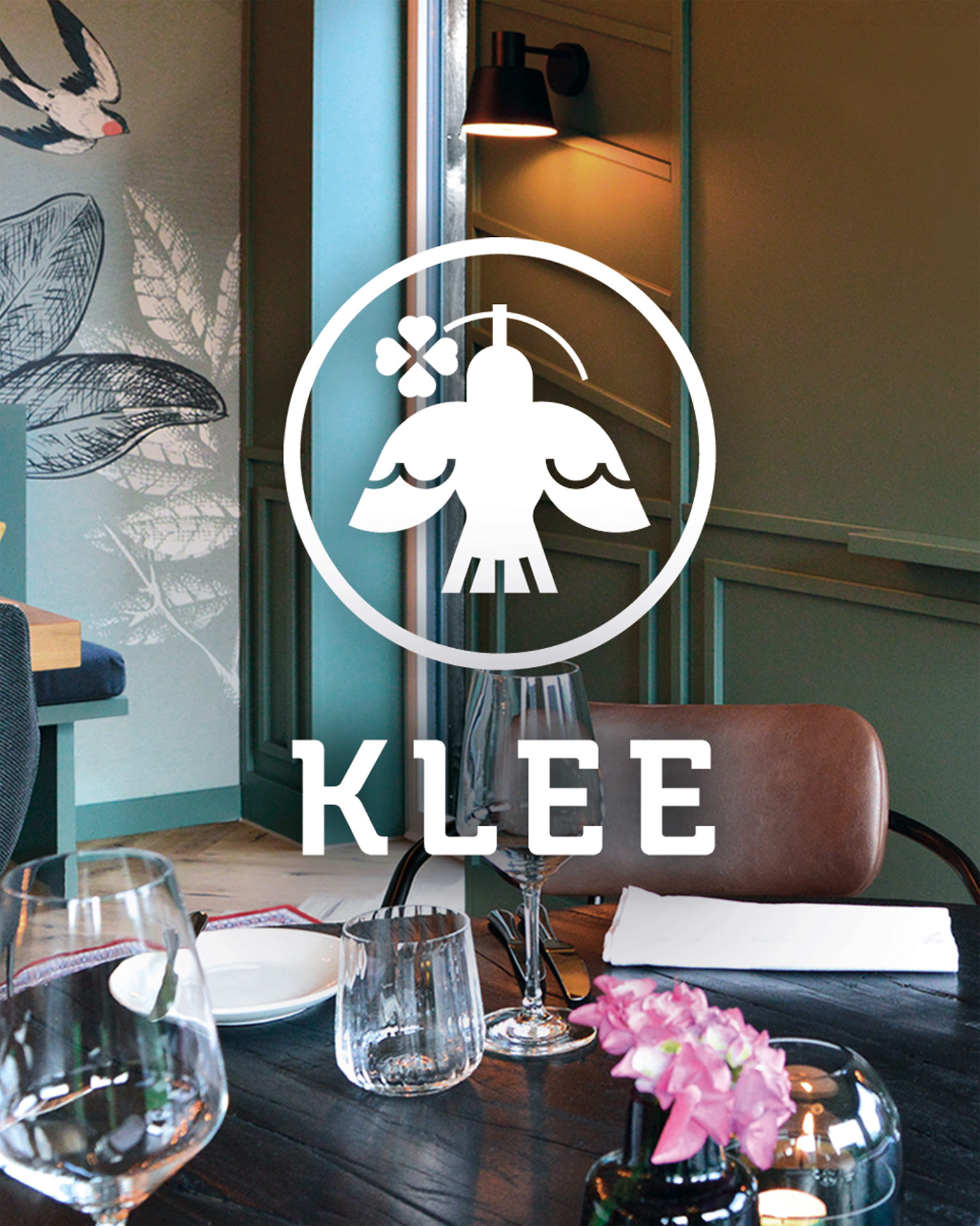 KLEE Tischsituation mit Logo-Wand im Hintergrund